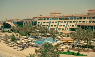 Al Raha Beach Resort & Spa beachfront property with swimming pool, sun loungers, palm trees, and resort facilities