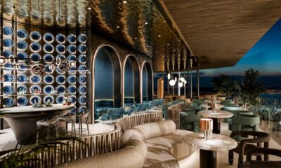 Luxury restaurant interior with decorative blue plate wall display, elegant seating, and open terrace with evening city views