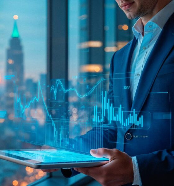 Business professional using tablet with holographic data analytics charts and graphs displayed against city skyline