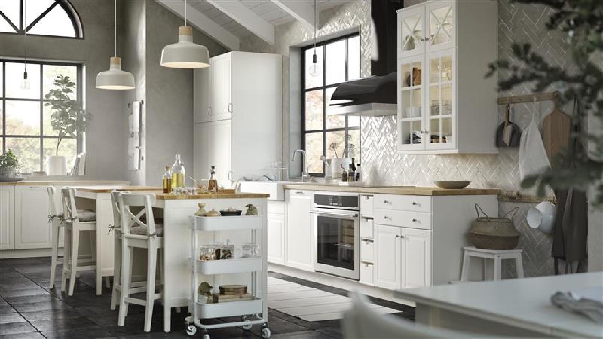 Modern Scandinavian-style kitchen with white cabinets, gray walls, pendant lighting, herringbone backsplash, and a central island with wooden countertop