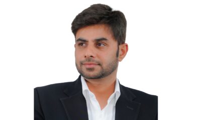 A wide-angle interior shot of a casual, brightly lit PizzaExpress restaurant shows dining tables, a communal bar area, and a large, colorful mural depicting a stylized map of Dubai on the wall.