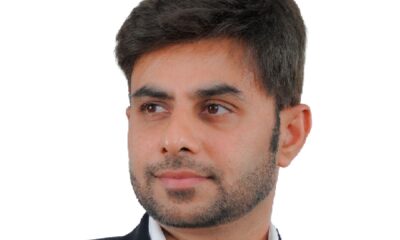 A wide-angle interior shot of a casual, brightly lit PizzaExpress restaurant shows dining tables, a communal bar area, and a large, colorful mural depicting a stylized map of Dubai on the wall.
