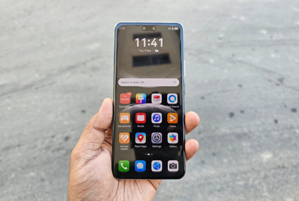 A person holding the Huawei Nova 14 Pro, displaying the home screen with the time and app icons.