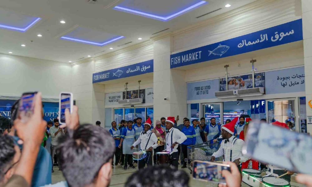 A wide-angle lifestyle photograph of the Waterfront Market Seafood Festival in Dubai, featuring a bustling promenade decorated with a unique seafood-themed festive tree.