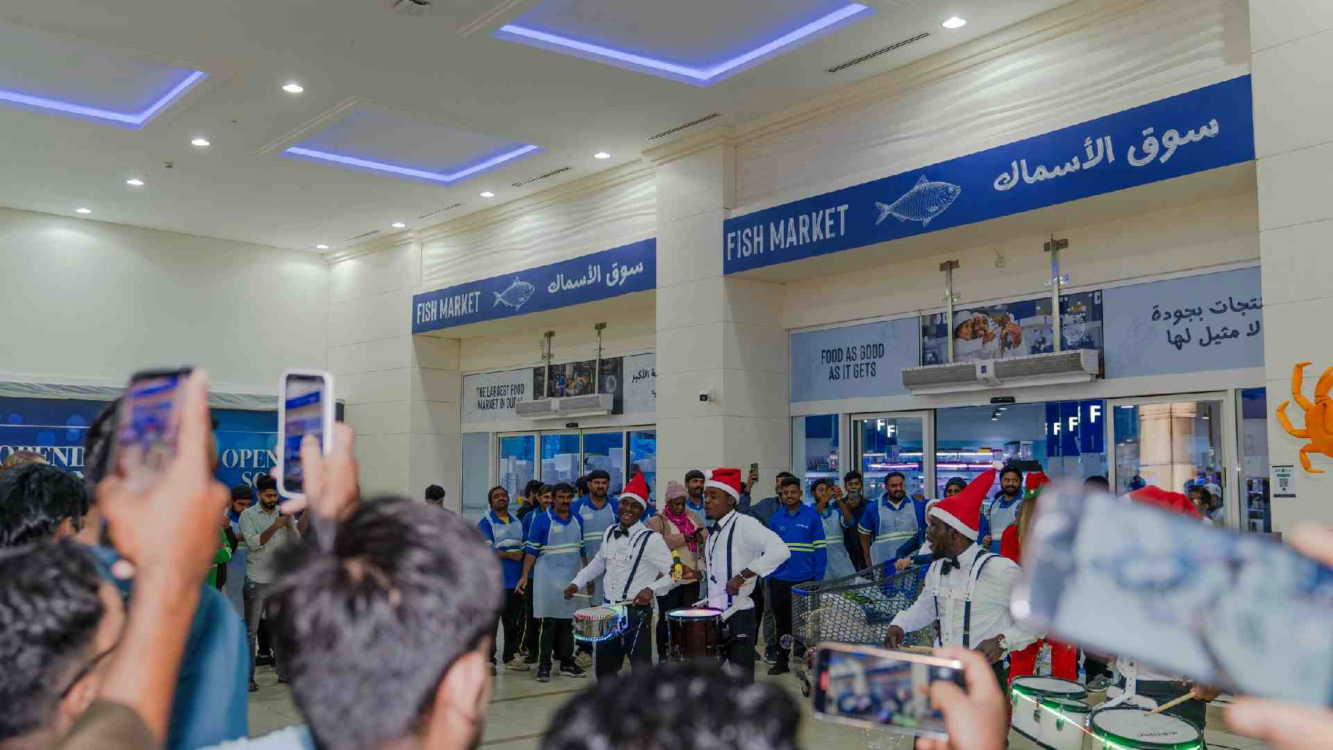 A wide-angle lifestyle photograph of the Waterfront Market Seafood Festival in Dubai, featuring a bustling promenade decorated with a unique seafood-themed festive tree.