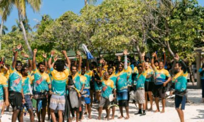 An aerial shot of hundreds of snorkelers gathered in the shallow turquoise water near the house reef at Siyam World Maldives, participating in the Guinness World Record attempt
