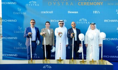 Groundbreaking ceremony for the RICHMIND Oystra project, showing the project team and executives posing with ceremonial shovels in the desert location on Al Marjan Island, Ras Al Khaimah