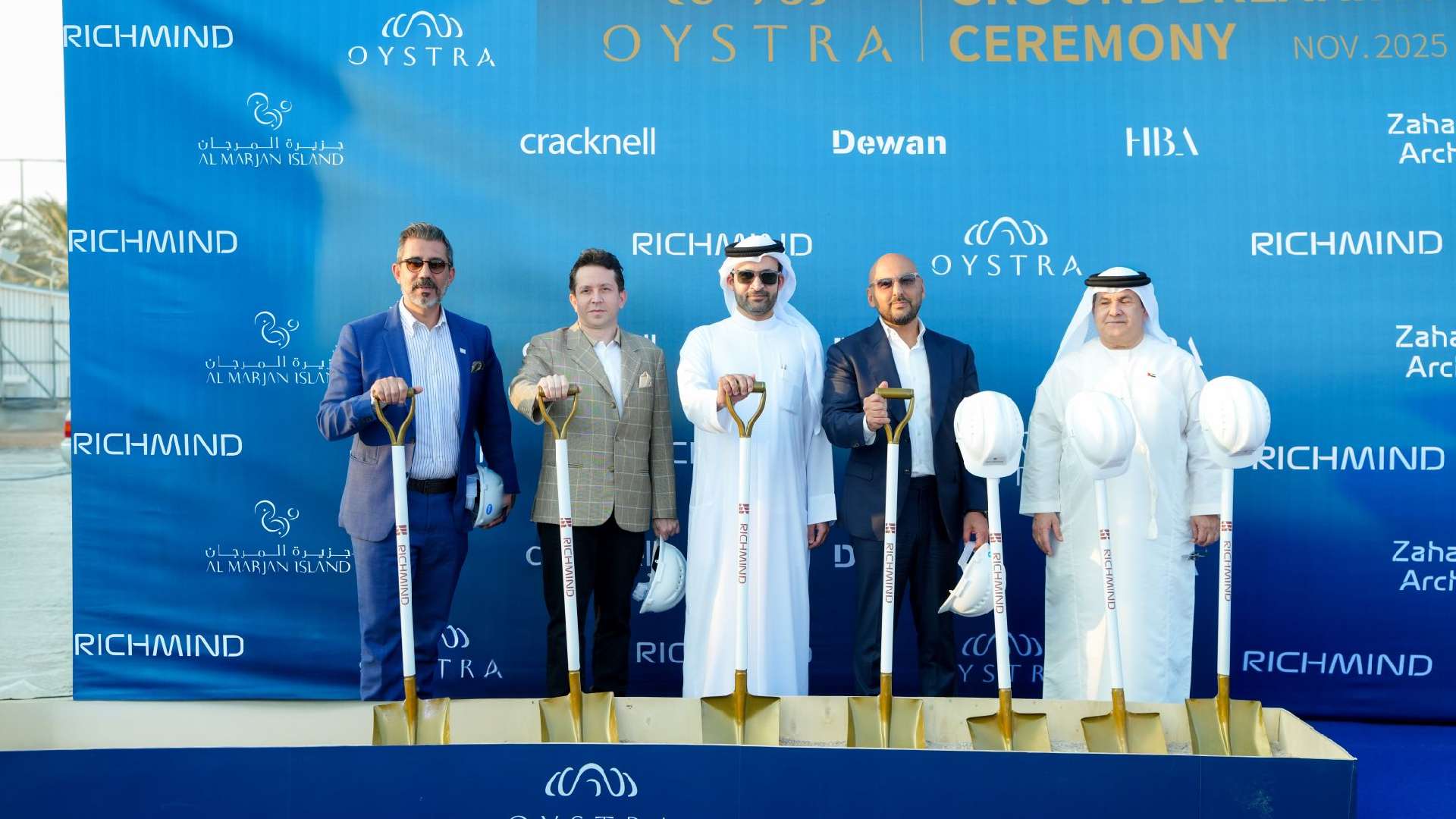 Groundbreaking ceremony for the RICHMIND Oystra project, showing the project team and executives posing with ceremonial shovels in the desert location on Al Marjan Island, Ras Al Khaimah
