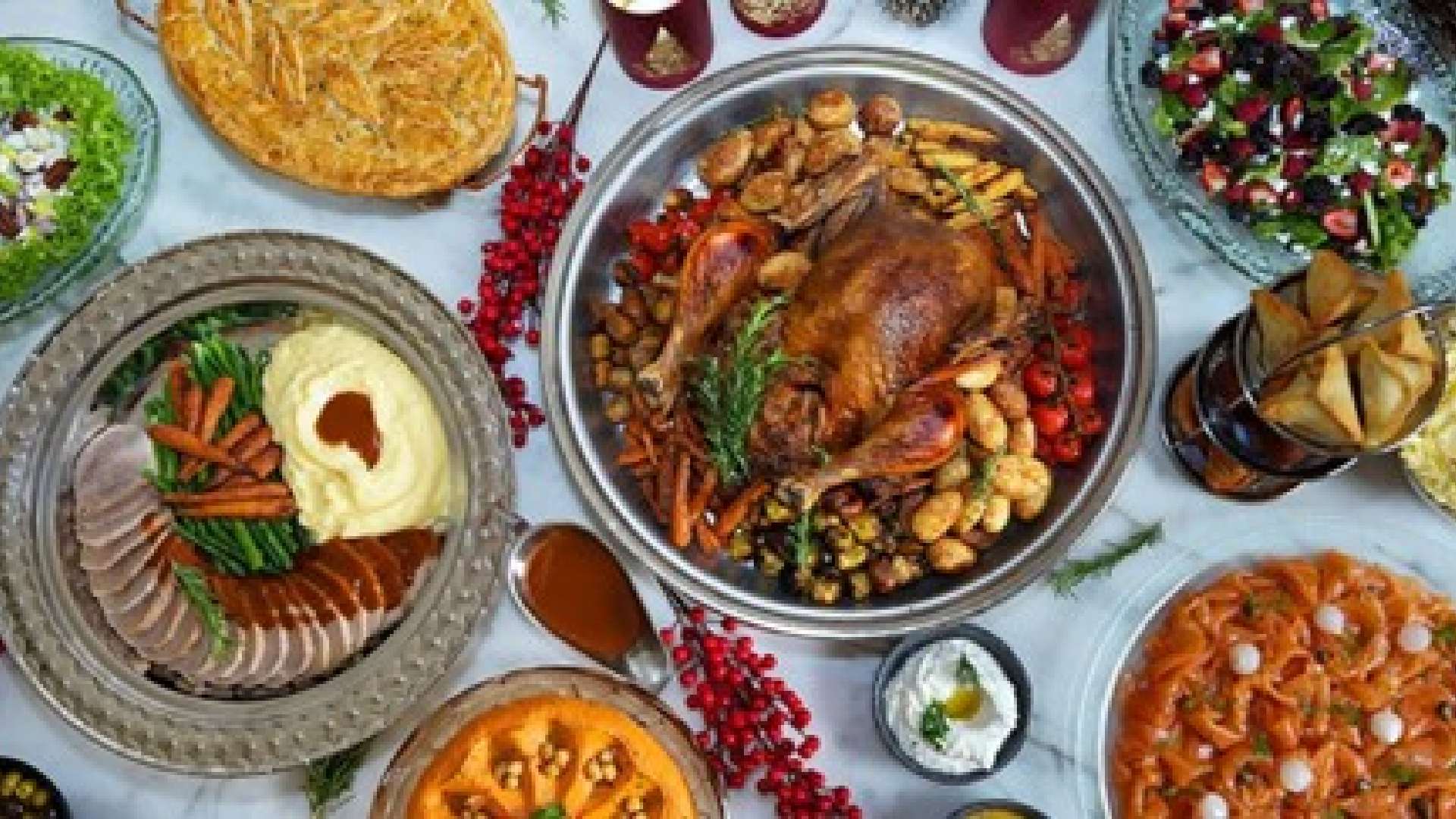 A beautifully presented whole Festive Roasted Turkey Feast from AL HALLAB, served with classic holiday accompaniments and Middle Eastern sides on a large platter.