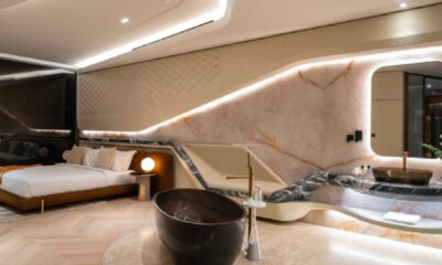 An architectural exterior shot of the Curve DiLusso villa by Alpago Group on Palm Jumeirah, featuring Pininfarina-conceived sculpted curves, floor-to-ceiling windows, and a luxury infinity pool overlooking the Dubai skyline