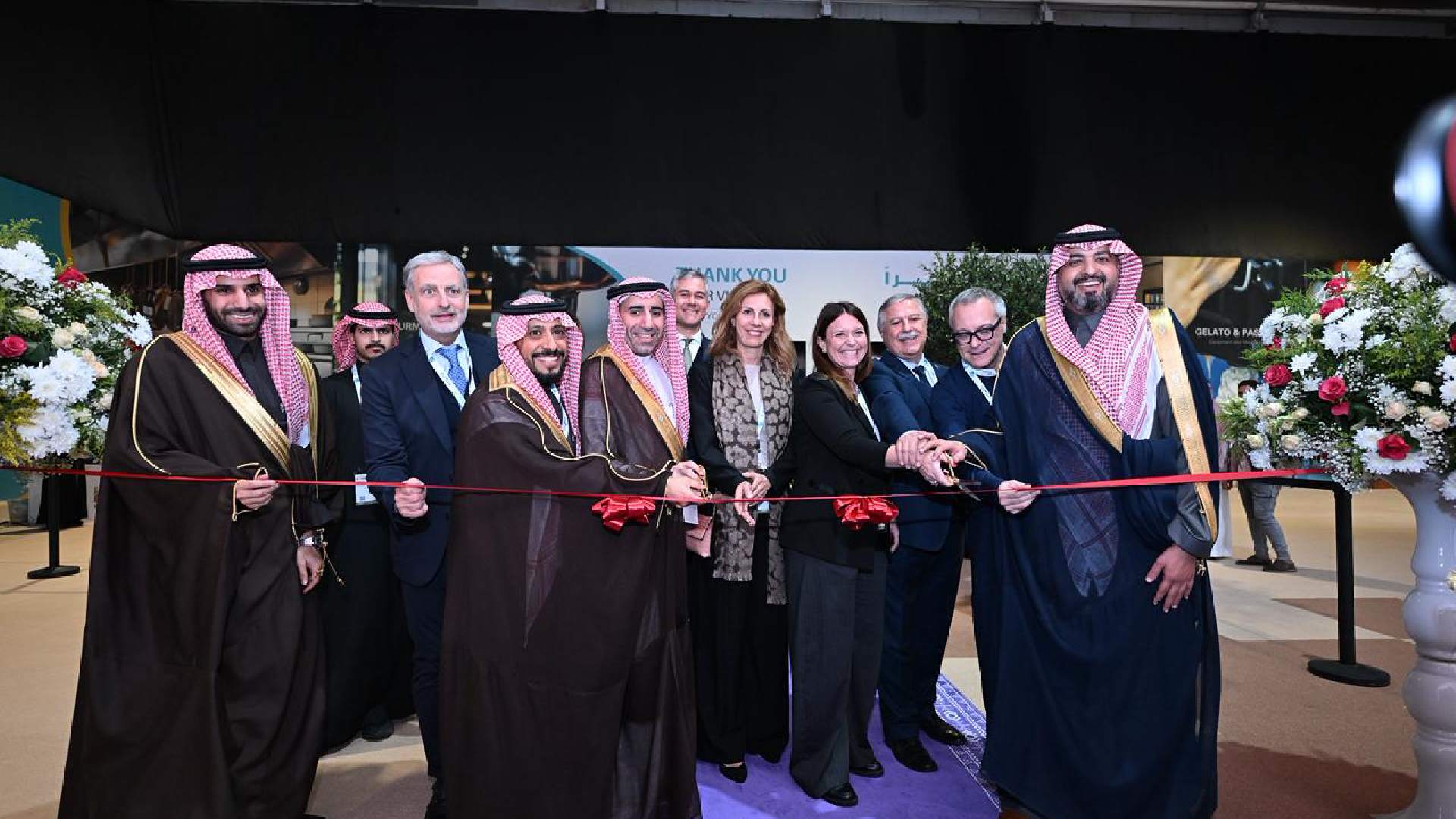 Ribbon-cutting ceremony at HORECA event with officials and organizers standing in front of floral arrangements, marking the official opening of the hospitality exhibition
