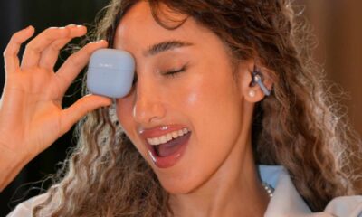 A lifestyle product photograph of the HUAWEI Mate XT ULTIMATE DESIGN, the world’s first commercially available trifold smartphone, being unfolded from its 6.4-inch phone size to its full 10.2-inch 3K display.