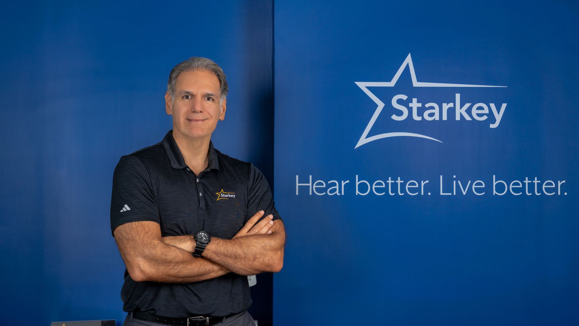 A professional corporate headshot of Giscard Bechara, Regional Director for Middle East & Africa at Starkey Laboratories Inc. He is presented in a modern, well-lit setting, wearing a tailored suit that reflects his leadership role in driving AI-enabled hearing innovation across the MEA region.
