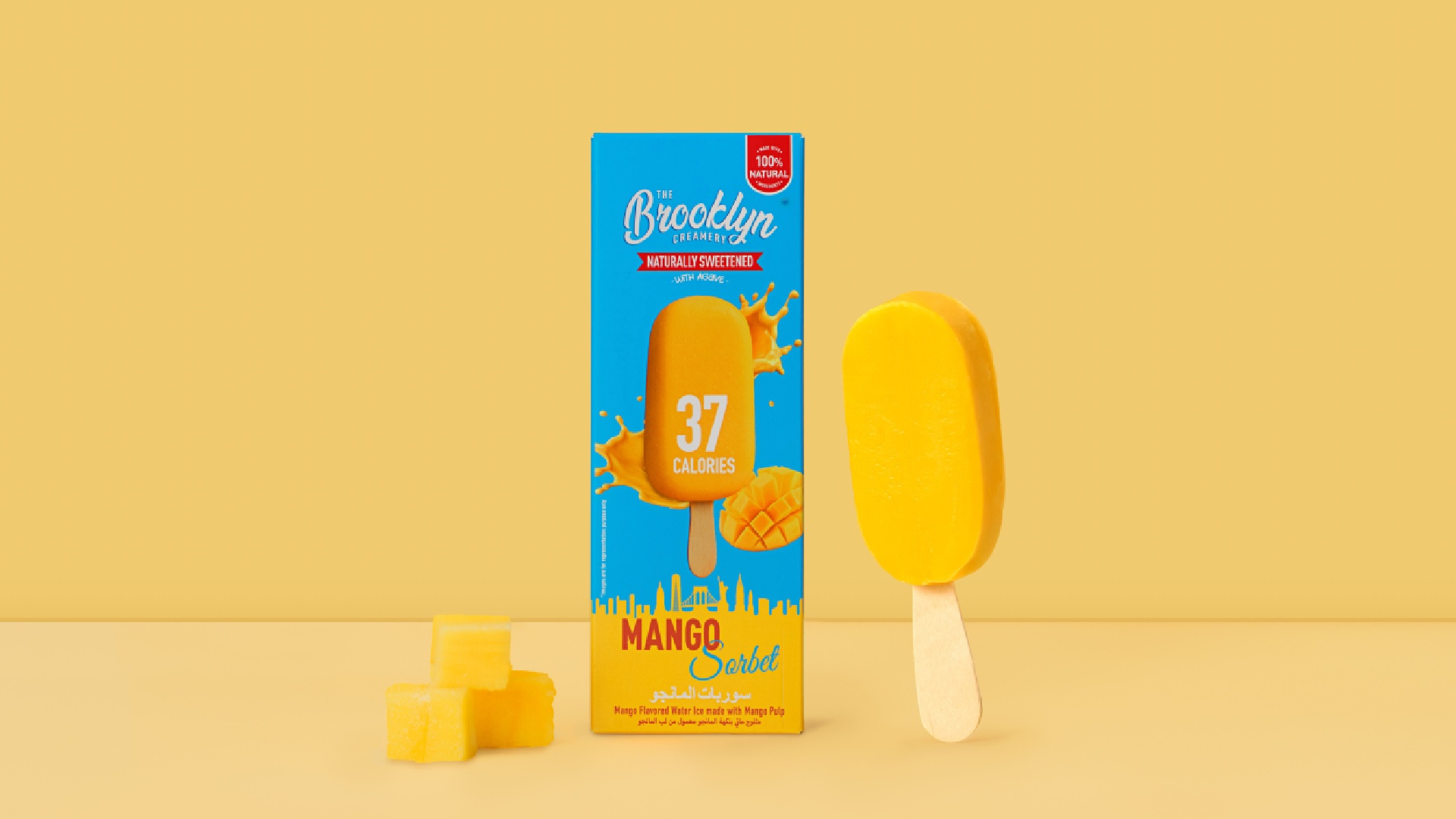 A close-up shot of The Brooklyn Creamery's 37-calorie Mango Sorbet Bar, showing the bright orange sorbet and a partially peeled wrapper on a white background.