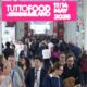 An aerial view of the crowded, expansive halls of the TUTTOFOOD trade show in Milan, showing rows of exhibitor booths and numerous professional visitors walking the aisles, highlighting the event's scale