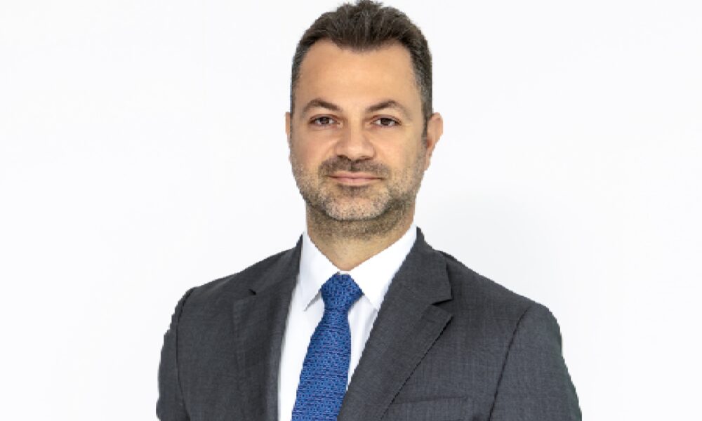 A wide view of a modern luxury lounge, TIMELESS, featuring a curved bar with a sculptural travertine counter, plush low seating, sophisticated warm lighting, and minimalist desert-inspired decor.