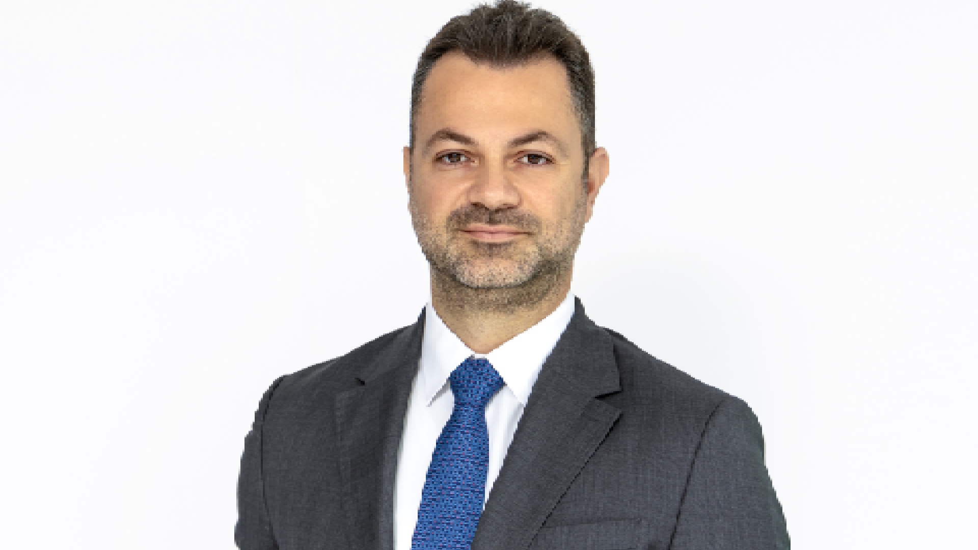 A wide view of a modern luxury lounge, TIMELESS, featuring a curved bar with a sculptural travertine counter, plush low seating, sophisticated warm lighting, and minimalist desert-inspired decor.