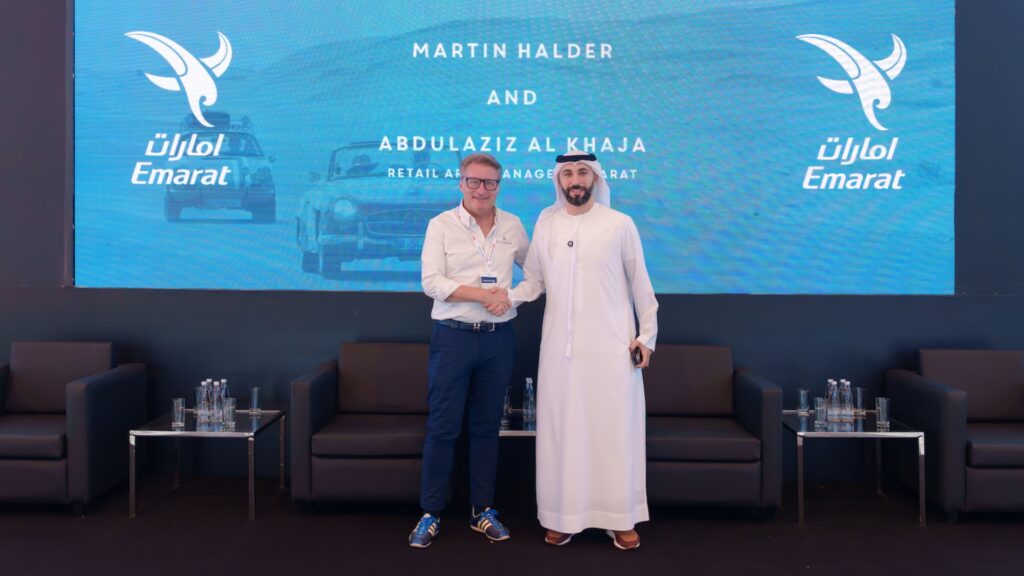 Martin Halder and Abdulaziz Al Khaja shaking hands in front of an Emarat logo screen.