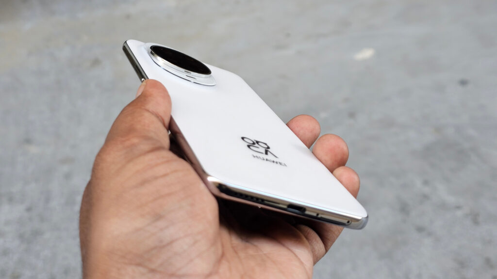 Angled close-up of the white Huawei Nova 14 Pro's back, showing the camera module and the bottom edge with the speaker grille.
