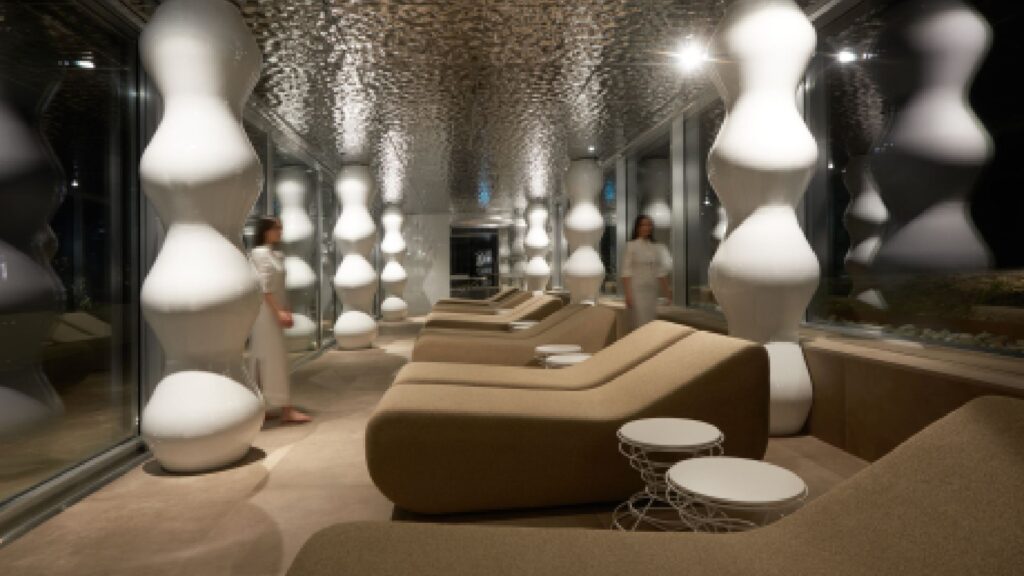 A professional portrait of architect Simone Micheli, the Architectural Hero, smiling and looking toward the viewer in a creative, modern interior setting.