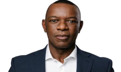 Person wearing a dark navy business suit over a white collared shirt, photographed against a plain white background. The image is a professional corporate portrait used for Enterprise DB branding