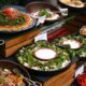A vibrant Ramadan buffet display at Mövenpick Hotel featuring assorted Middle Eastern salads, fresh vegetables, mezze dishes, and bowls of colorful ingredients arranged neatly on wooden risers and decorative tableware.