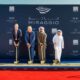 Source of Fate officials and partners participate in a ceremonial ground‑breaking for the Miraggio development on Al Marjan Island, holding shovels on a red carpeted site in front of a branded Miraggio and Source of Fate backdrop.
