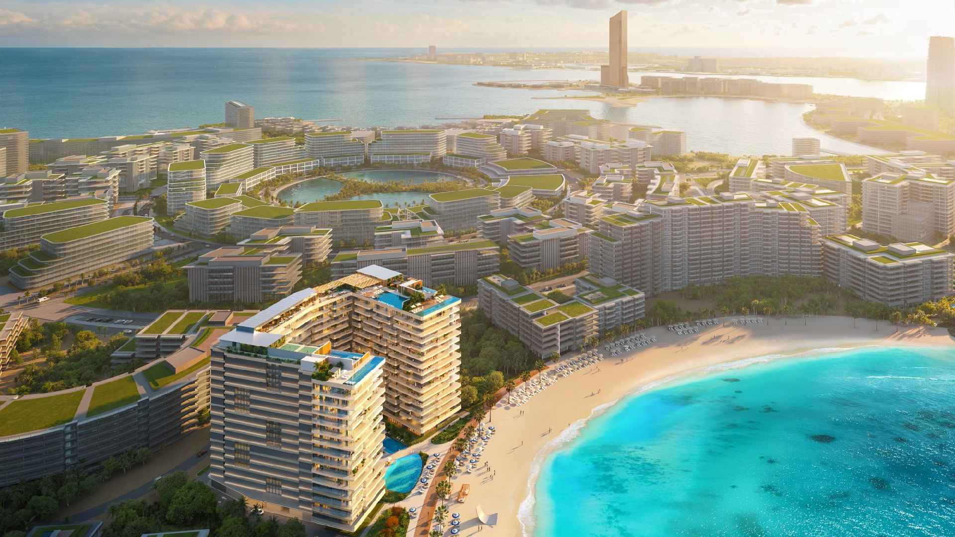 Aerial view of the ELEVATE coastal masterplan showing modern mid-rise buildings with green rooftops surrounding lagoons, beachfront residences with swimming pools, a sandy beach, and turquoise sea.