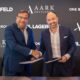 Signing ceremony between AARK DEVELOPERS and One Broker Group for Karl Lagerfeld Beach Residences, with representatives shaking hands and holding signed documents in front of branded backdrop.