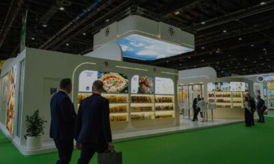 Solico Group exhibition stand at a trade show, featuring illuminated product displays while visitors walk and view food products.