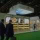 Solico Group exhibition stand at a trade show, featuring illuminated product displays while visitors walk and view food products.