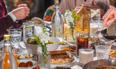 Shared Iftar table at Blume featuring Middle Eastern dishes, flatbreads, dips, dates, drinks, and lanterns as guests serve food together