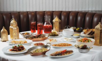 Ramadan Iftar table at FUMÉE STEAKHOUSE featuring shared mezze, grilled meats, soups, bread, desserts and traditional lanterns set on a white tablecloth.