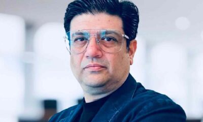 Professional portrait of a Gllit Technologies team member standing with arms crossed in a modern office setting