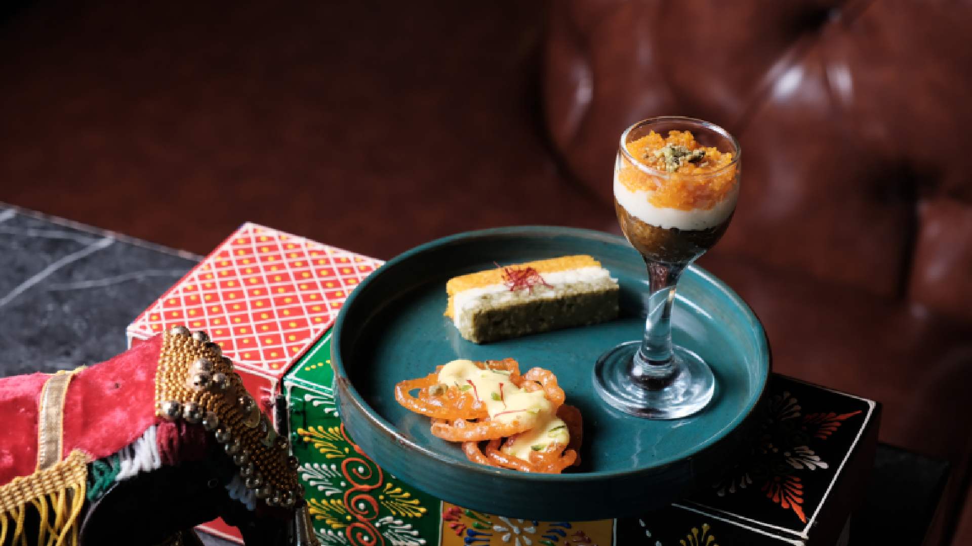 ROHINI tricolour-inspired Indian desserts served on a platter, featuring jalebi with rabdi, layered kalakand, and a dessert glass, styled for Republic Day presentation.