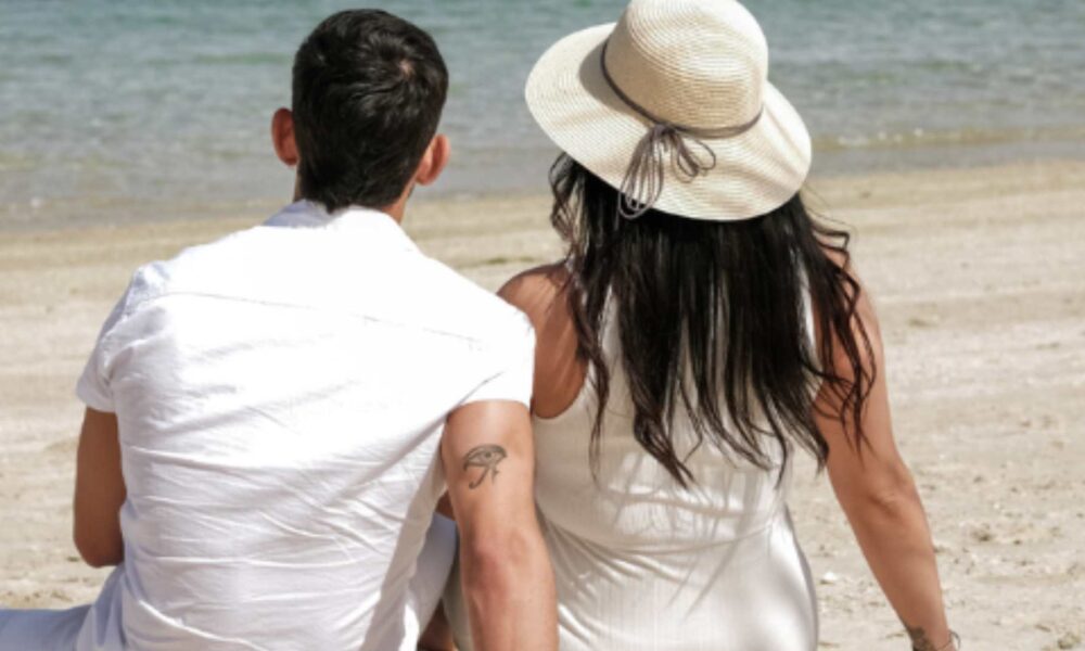 couple sitting together, sitting together in sand