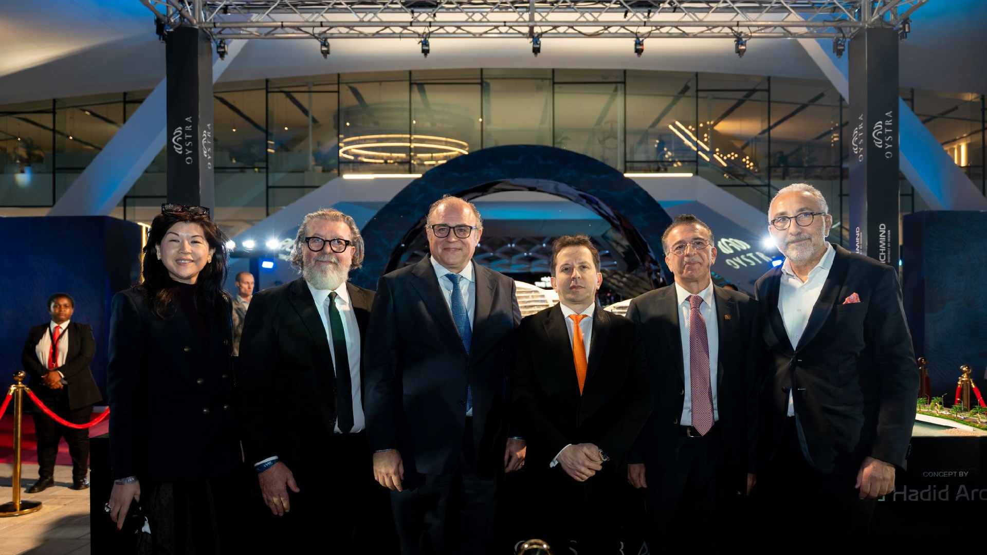 Richmind executives and partners posing at the Oystra Phase 2 launch event at Ain Dubai, standing in front of the architectural Oystra display with branded lighting and red carpet stanchions.