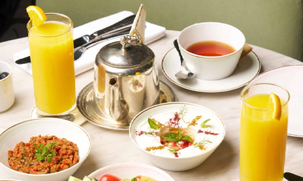 Ladurée Valentine’s macaron gift boxes displayed on a pink background, featuring heart-shaped pink macarons, branded pastel boxes, and delicate floral ribbon accents.