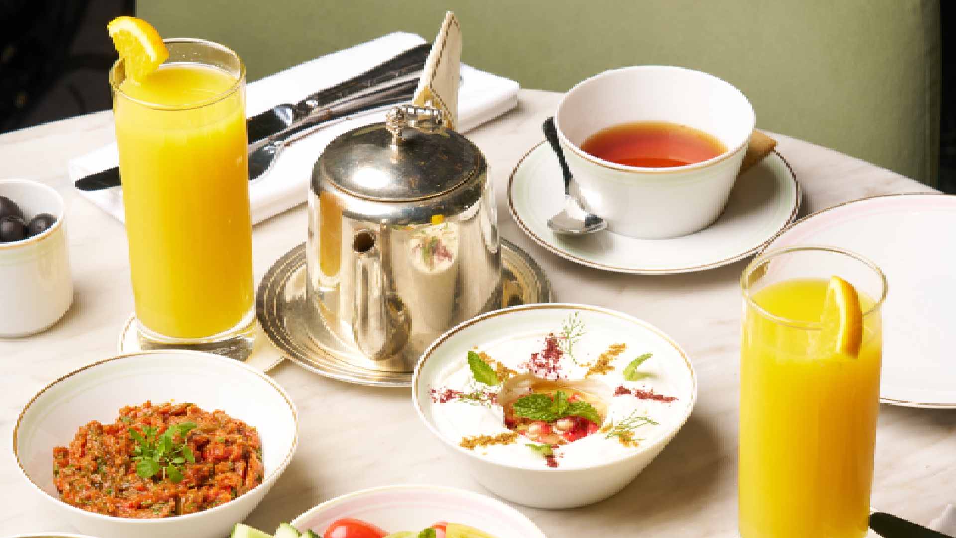 Ladurée Valentine’s macaron gift boxes displayed on a pink background, featuring heart-shaped pink macarons, branded pastel boxes, and delicate floral ribbon accents.