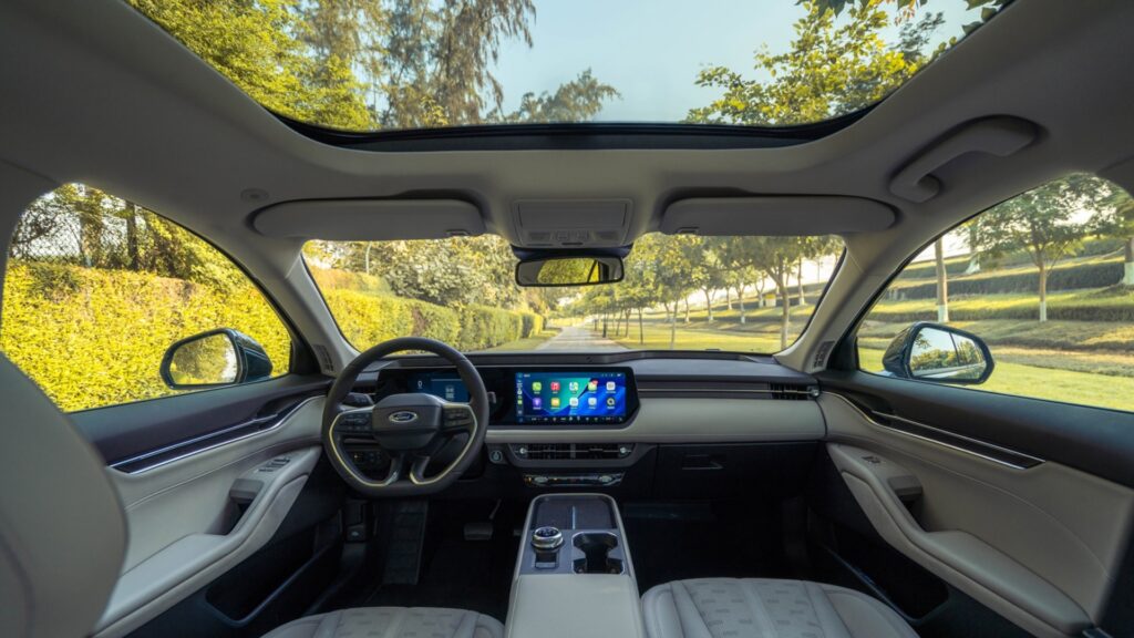 The interior cabin of a Ford Taurus viewed from the back seat.