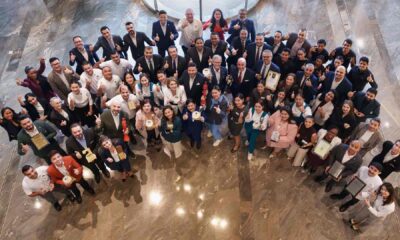 DAMAC Hospitality earns over 30 awards recognising excellence in luxury hospitality, leadership and guest experience. Group of DAMAC Hospitality team members standing together in a marble-floored atrium, holding multiple industry awards and trophies while posing for a celebratory group photo.