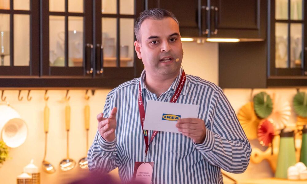 IKEA staff member presenting an Iftar offering in a modern kitchen showroom with warm lighting and Ramadan décor.