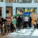 Families and children queue around a colourful HAG AL LEILA activation inside a Dubai shopping mall, where staff distribute sweets and lead festive activities in a decorated central atrium