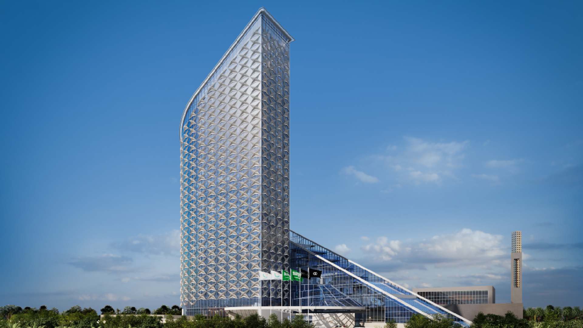 Exterior view of Sofitel Riyadh showing a tall, angular hotel tower with patterned facade, glass podium and Saudi flags at the entrance under a clear blue sky.