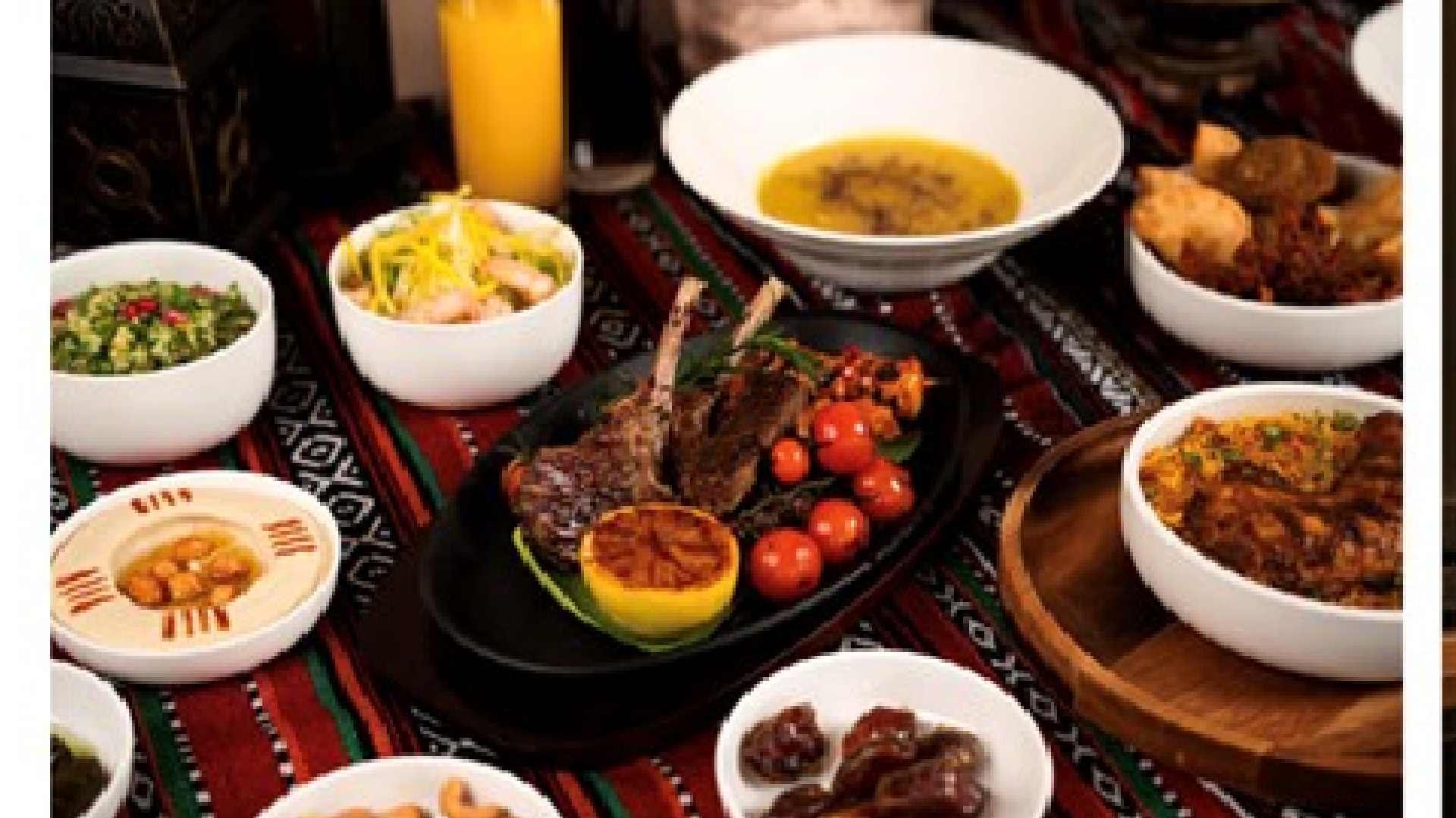 Ramadan Iftar spread with grilled lamb, dates and traditional dishes beside an elegant dining room with Marina views at DUBAI MARRIOTT HARBOUR HOTEL & SUITES