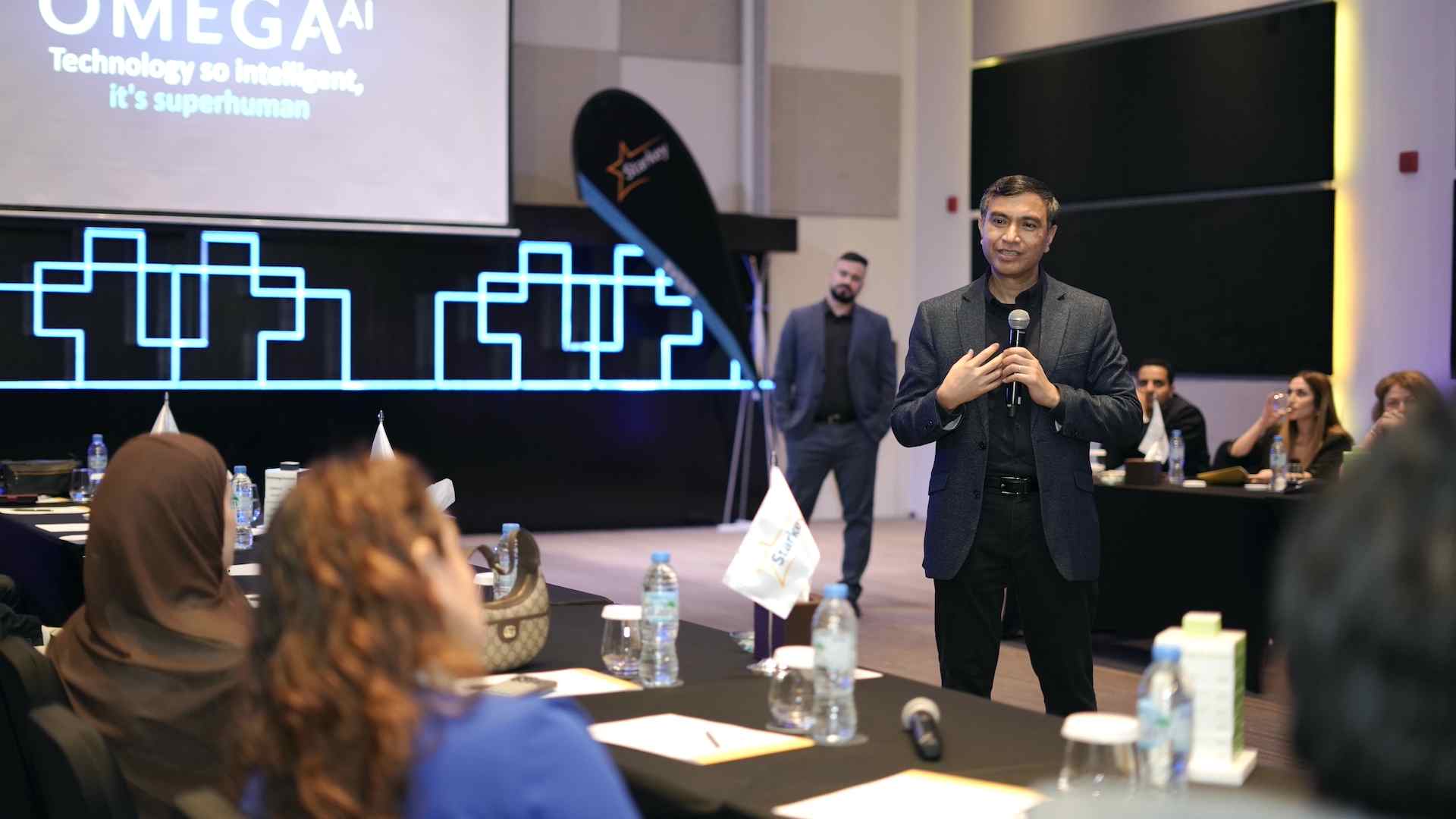 Starkey MEA speaker presenting Omega AI hearing technology to audiologists and industry professionals during a conference session in Dubai.