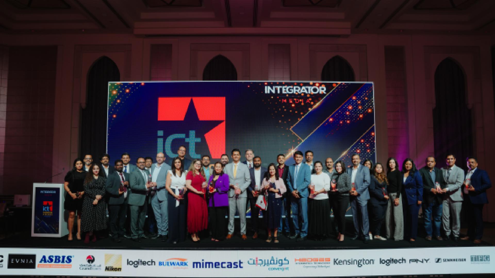 Award winners and industry leaders stand on stage at Integrator Media – the ICT Champion Awards 2026 in Dubai, holding trophies beneath the ICT Champion Awards backdrop.