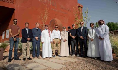 Group site visit showing senior representatives and project stakeholders standing outside the NUMAJ building in AlUla during the construction commencement milestone.